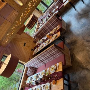 Drewniane wnętrze restauracji z dużymi oknami i przytulnym klimatem